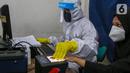 Petugas Dukcapil lengkap dengan APD memindai sidik jari KTP Elektronik di Kecamatan Pamulang, Tangerang Selatan, Senin (15/6/2020) Dukcapil Tangsel membuka layanan rekaman E-KTP jelang Pilkada dengan menerapkan ketentuan New Normal guna mencegah penyebaran Virus Covid-19. (Liputan6.com/Fery Pradolo)