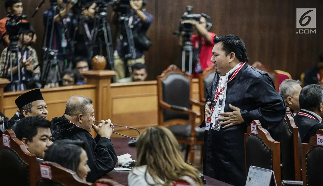 Anggota Tim Hukum Joko Widodo-Ma’ruf Amin, Ade Irfan Pulungan (kanan) jelang sidang lanjutan sengketa Pilpres 2019 di Gedung MK, Jakarta, Kamis (20/6/2019). Agenda sidang kali ini mendengarkan keterangan saksi dan ahli dari pihak termohon Komisi Pemilihan Umum (KPU). (Liputan6.com/Faizal Fanani)