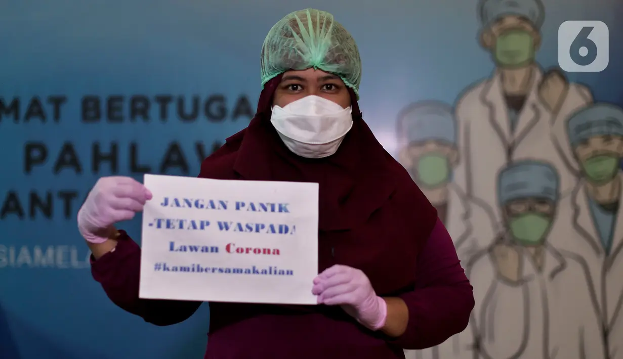 Dokter dan tenaga medis membawa tulisan berisi pesan dan tulisan untuk melawan virus corona saat sesi foto di posko tenaga medis Covid-19, Jakarta, Kamis (2/4/2020). Aksi ini mengharapkan masyarakat berdiam diri di rumah, untuk ikut bergerak memutus mata rantai covid-19. (Liputan6.com/Johan Tallo)