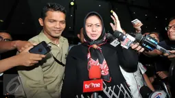 Istri Pelaksana Tugas (Plt) Gubernur Sumatera Utara Tengku Erry Nuradi, Evi Diana, menghindar dari wartawan usai diperiksa KPK, Jakarta, Kamis (5/11/15). Evi yang diperiksa sebagai saksi untuk Gatot Pujo Nugroho. (Liputan6.com/Helmi Afandi) 