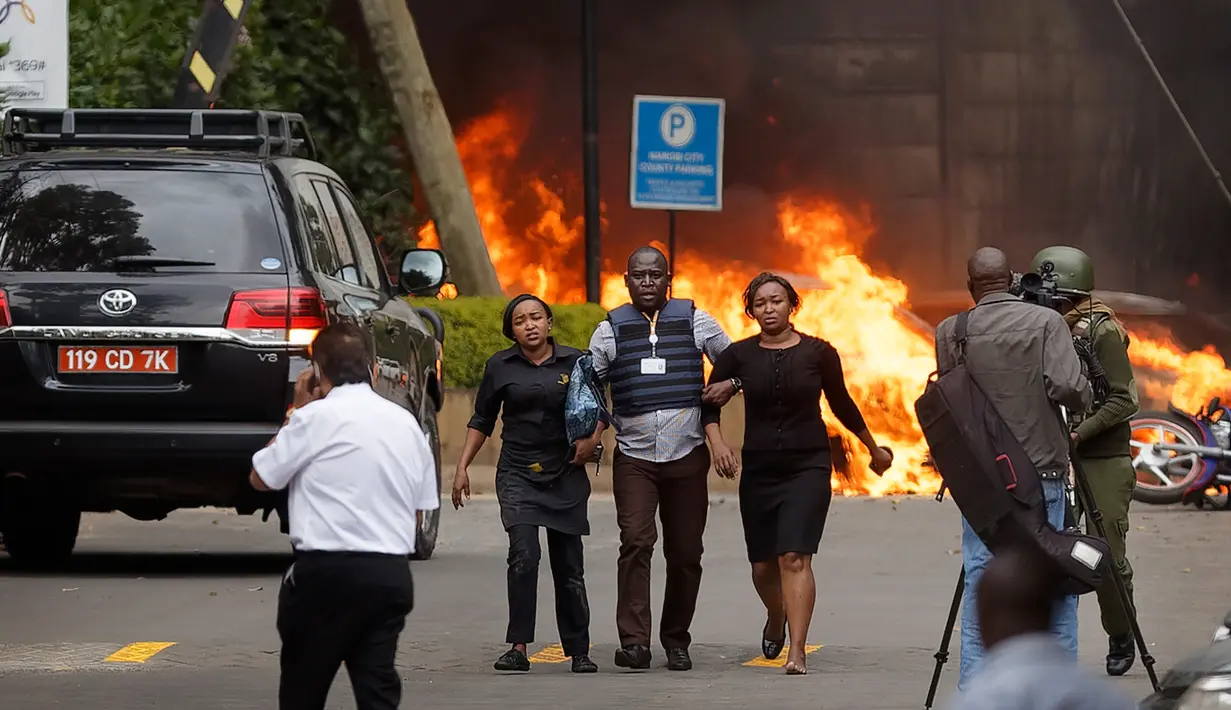 Pasukan keamanan membantu warga melarikan diri dari lokasi penyerangan sebuah kompleks hotel mewah di Nairobi, Kenya, Selasa (15/1). Dilansir dari CNN, 15 orang dinyatakan tewas dalam serangan tersebut. (AP Photo/Ben Curtis)
