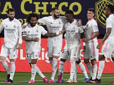 Para pemain Real Madrid merayakan gol yang dicetak oleh Karim Benzema ke gawang Cadiz pada laga Liga Spanyol di Stadion Ramon de Carranza, Rabu (22/4/2021). Real Madrid menang dengan skor 3-0. (AP Photo/Jose Breton)