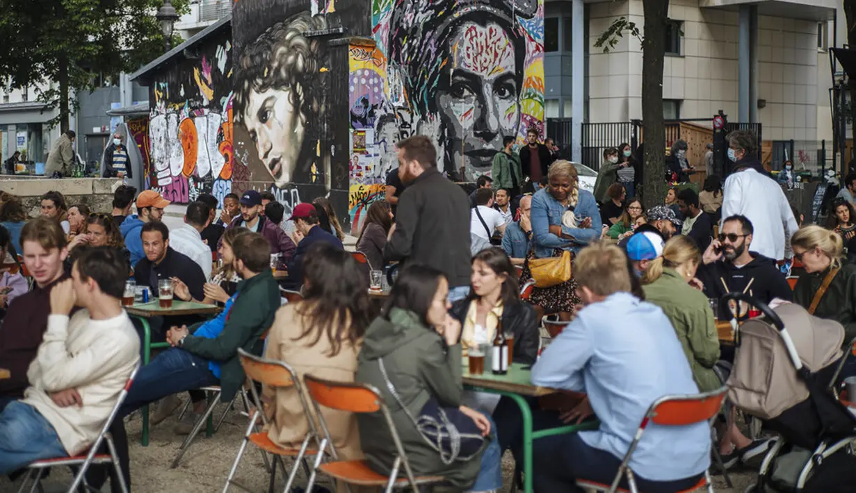 Orang-orang bersosialisasi dan minum di teras kafe di Paris, Prancis, Sabtu (5/6/2021). Jumlah kasus baru COVID-19 di Prancis semakin menurun. (AP Photo/Lewis Joly)