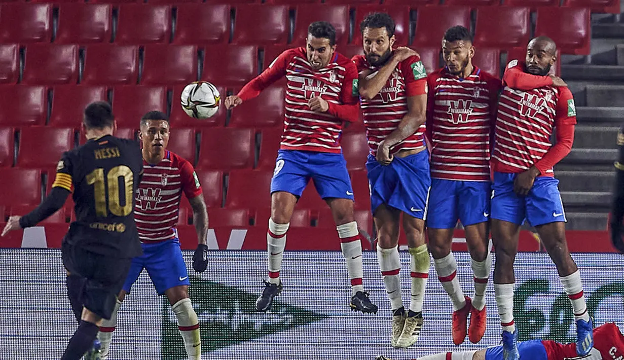 Pemain Barcelona Lionel Messi melakukan tendangan bebas saat melawan Granada pada pertandingan perempat final Copa del Rey di Stadion Los Carmenes, Granada, Spanyol, Rabu (3/2/2021). Barcelona sukses kalahkan Granada 5-3 dan mendapatkan tiket semifinal Copa del Rey. (AP Photo)