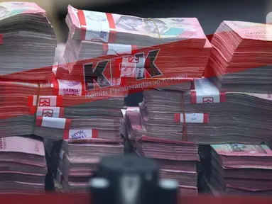 Tumpukan uang barang bukti hasil Operasi Tangkap Tangan (OTT) terduga pelaku tindak pidana korupsi terkait penerimaan atau janji dalam pengurusan sengketa lahan di Pengadilan Negeri Depok di gedung Merah Putih Komisi Pemberantasan Korupsi (KPK), Jakarta, Jumat (6/2/2026). Komisi Pemberantasan Korupsi (KPK) kembali berhasil menangkap para terduga pelaku tindak pidana korupsi melalui serangkaian Operasi Tangkap Tangan (OTT). (Liputan6.com/Helmi Fithriansyah)