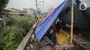 Pengungsi banjir beristirahat dalam tenda yang didirikan di jalur rel kereta commuterline Tangerang-Duri di Kembangan Baru, Jakarta, Jumat (3/1/2020). Jalur rel yang nonaktif sementara karena banjir dimanfaatkan warga untuk mendirikan tenda darurat. (Liputan6.com/Faizal Fanani)