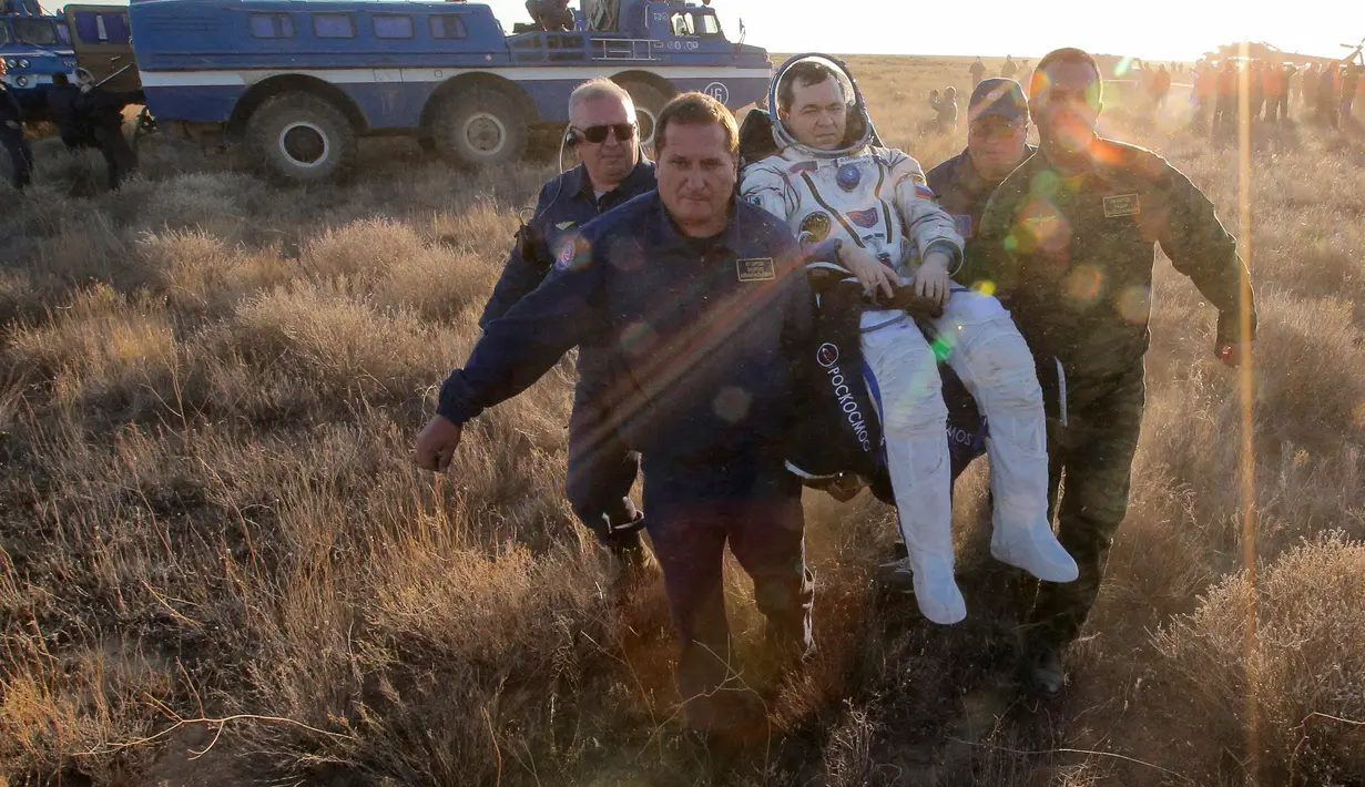 Para tim penyalamat mengangkat astronaut Stasiun Luar Angkasa Internasional (ISS), Oleg Skripochka dari Rusia setelah berhasil mendarat di dekat Kota Zhezkazgan, Kazakhstan, (7/9). (Bill Ingalls/NASA/Reuters)