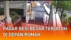 Terekam kamera CCTV sebuah pagar besi rumah terjatuh di depan jalan.