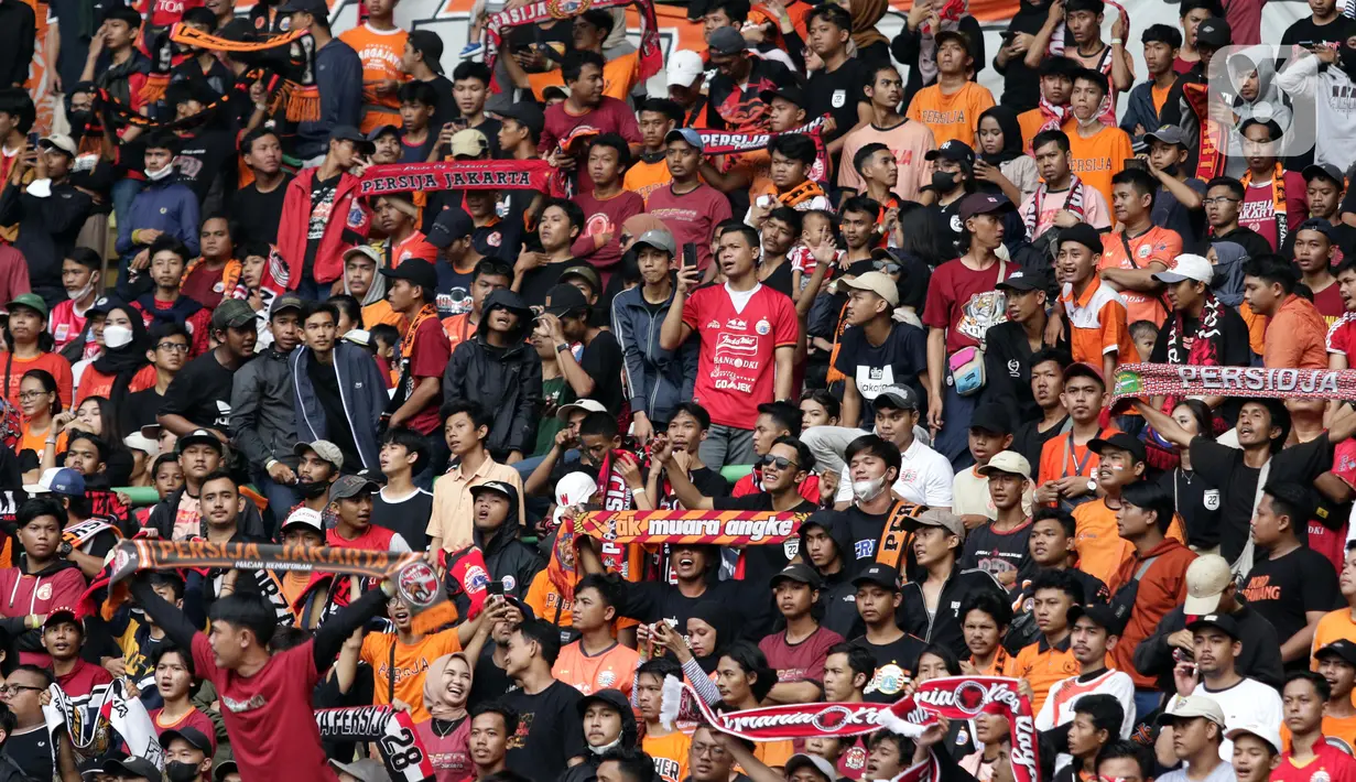 Suporter saat menyaksikan laga Persija melawan Sabah FC pada laga uji coba internasional di Stadion Patriot Candrabhaga, Kota Bekasi, Minggu (5/6/2022). Pertandingan sepakbola kembali bisa disaksikan secara langsung setelah pemerintah melonggarkan aturan pemakaian masker di luar ruangan. (Liputan6.com/Helmi Fithriansyah)