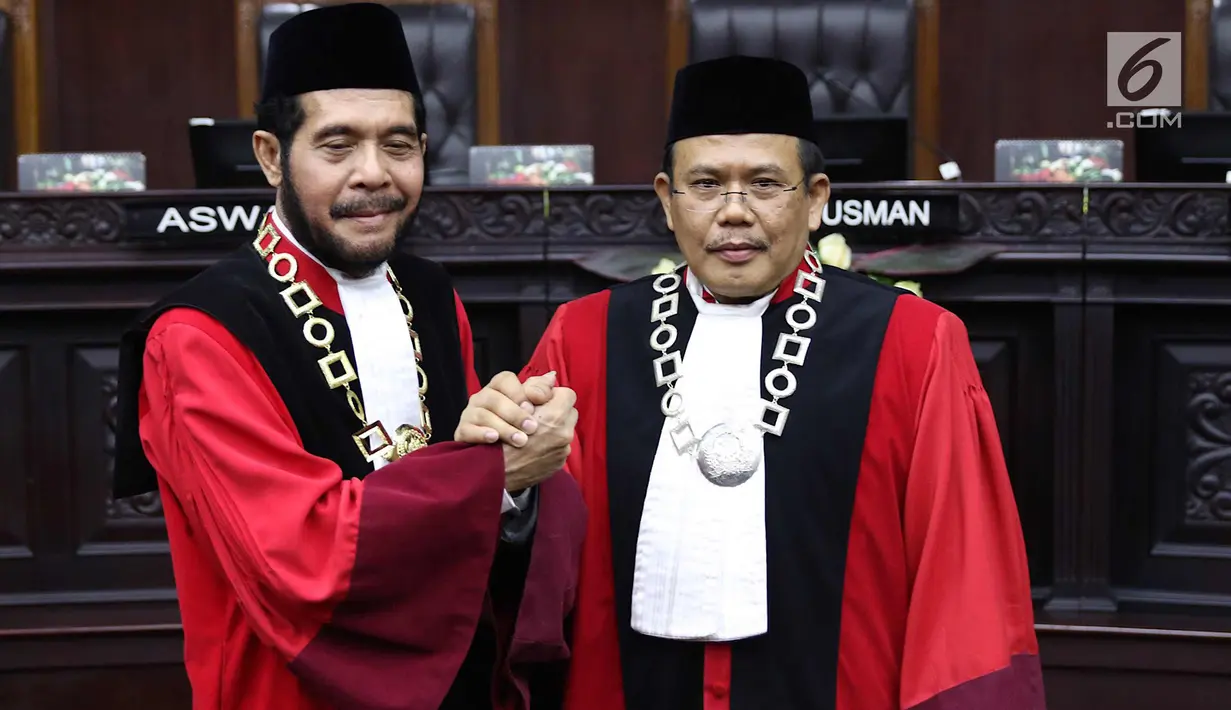 Ketua Mahkamah Konstitusi (MK) terpilih Anwar Usman (kiri) berjabat tangan dengan Wakil Ketua terpilih Aswanto usai acara pengucapan sumpah jabatan Ketua dan Wakil Ketua MK di gedung MK, Jakarta, Senin (2/4). (Liputan6.com/Immanuel Antonius)
