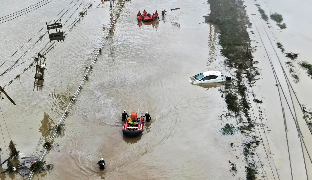 Foto udara menunjukkan penduduk dievakuasi dengan perahu menyusul hujan lebat di Kumamura, prefektur Kumamoto, Jepang,  Minggu (5/7/2020). Banjir yang memicu tanah longsor ini telah menghancurkan ratusan rumah dan kendaraan serta membuat jembatan antar kota terputus. (Koji Harada/Kyodo News via AP)