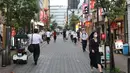 Orang-orang yang mengenakan masker berjalan di Minato-ku, Tokyo, Jepang (30/6/2020). Pemerintah kota metropolitan Tokyo mengonfirmasi 54 kasus infeksi baru COVID-19, menandai hari kelima berturut-turut penambahan kasus harian baru di ibu kota tersebut. (Xinhua/Du Xiaoyi)