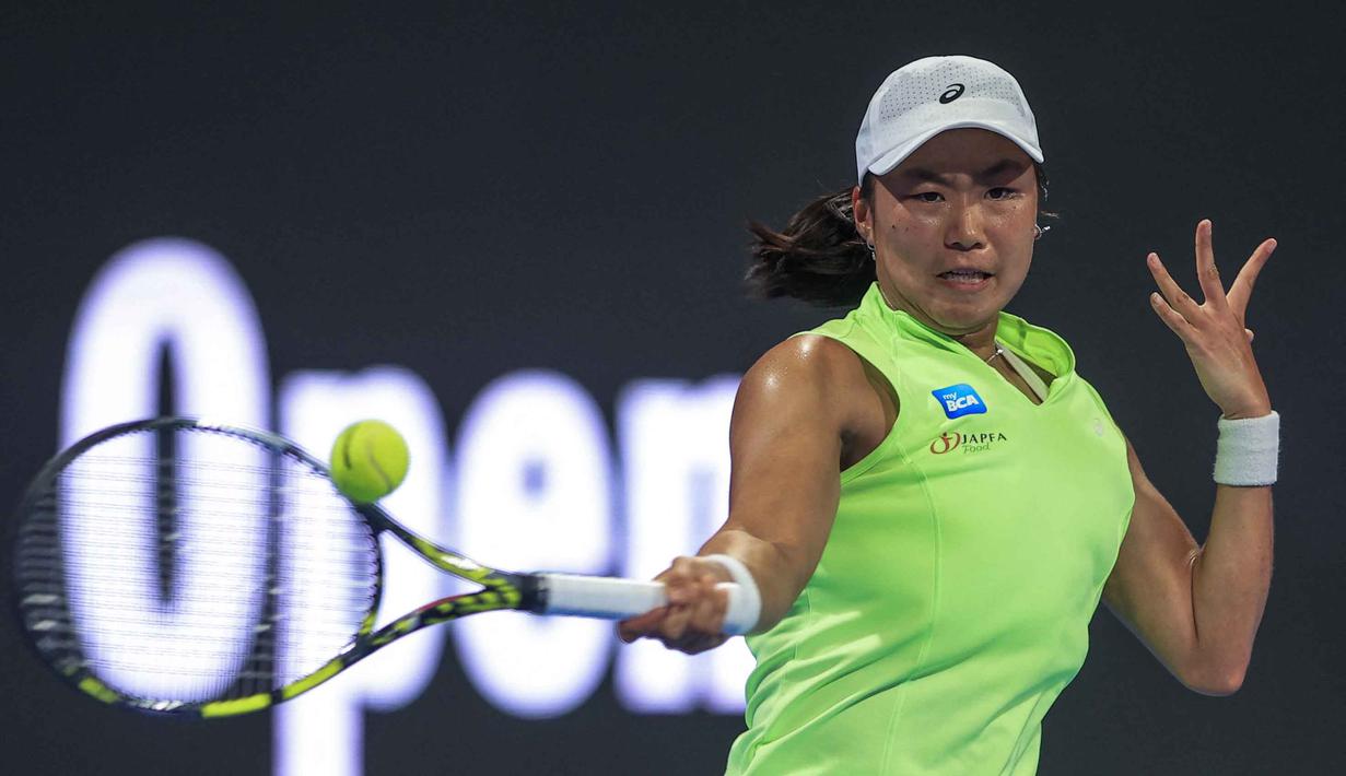 Petenis tunggal putri Indonesia, Janice Tjen memukul bola balasan saat melawan Iga Swiatek (Polandia) pada babak kedua turnamen Qatar Open di Doha, 10 Februari 2026. (Karim JAAFAR/AFP)