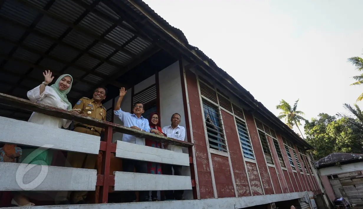 Wapres Jusuf Kalla didampingi sang istri, Mufidah Kalla melambaikan tangan pada warga Bone saat mengunjungi rumah ayahnya, di Dusun Nipah, Desa Mallari Kecamatan Awangpone, Kabupaten Bone, Sulawesi Selatan,  Sabtu (6/6). (Liputan6.com/Faizal Fanani)
