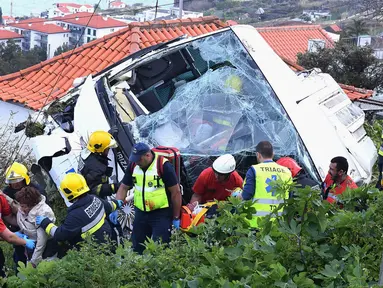 Petugas penyelamat mengevakuasi korban kecelakaan sebuah bus pariwisata di Kota Canico, Pulau Madeira, Portugal, Rabu (17/4). Sebanyak 28 orang yang sebagian besar turis dari Jerman, meninggal dunia, sementara 22 lainnya terluka dalam insiden tersebut. (Rui Silva/Aspress/Global Imagens via AP)