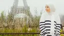 Tya Ariestya memilih keliling Eropa bersama suami dan anak-anaknya. Saat di Paris, ia mengenakan kerudung putih dipadukan sweater putih bergaris hitam serta rok denimnya. [@tya_ariestya]