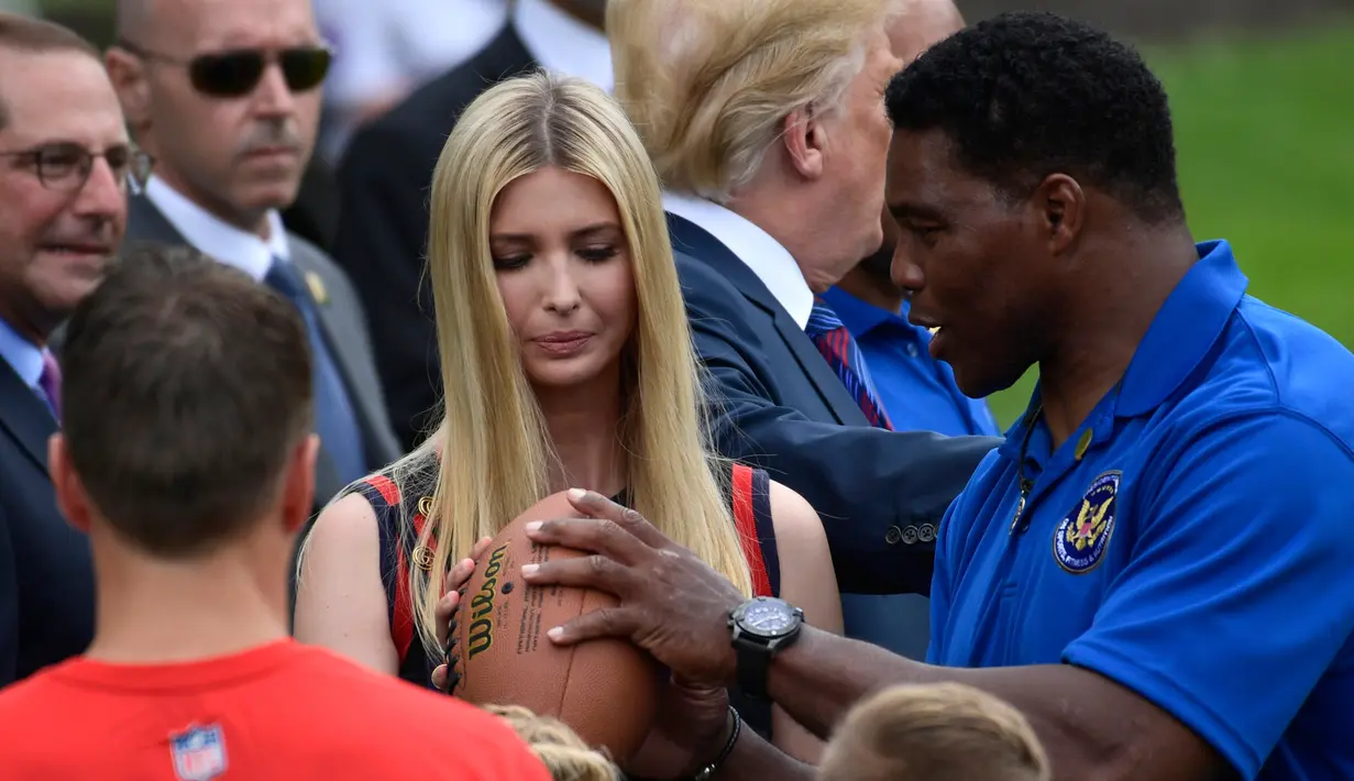 Ivanka Trump belajar melempar bola dari Herschel Walker selama acara White House Sports and Fitness Day" di Gedung Putih, Washington, AS, (30/5). Ivanka tampil cantik dengan rambut diurai saat belajar bermain rugby. (AP Photo / Susan Walsh)