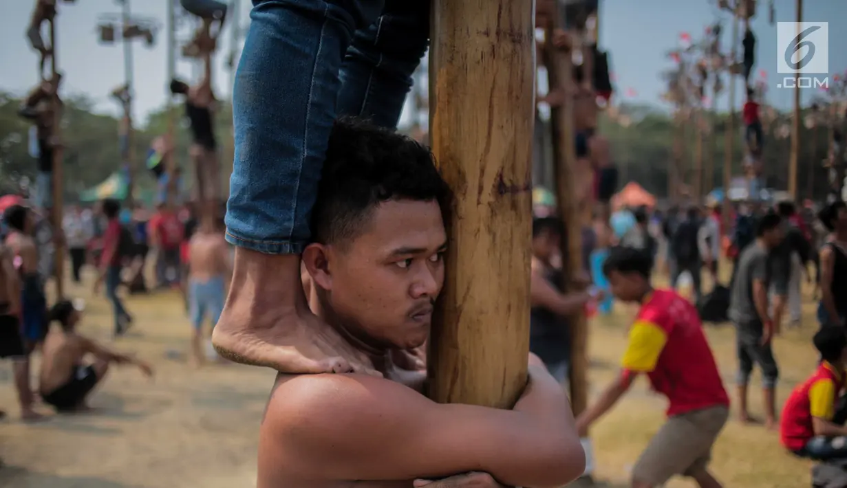 Ekspresi seoran warga saat mengikuti lomba Panjat Pinang Kolosal dalam rangka merayakan HUT ke-74 Kemerdekaan RI di Pantai Karnaval Ancol, Jakarta, Senin (17/8/2019). Sebanyak 174 batang pinang dengan beragam hadiah disediakan dalam lomba yang diikuti ratusan warga itu. (Liputan6.com/Faizal Fanani)