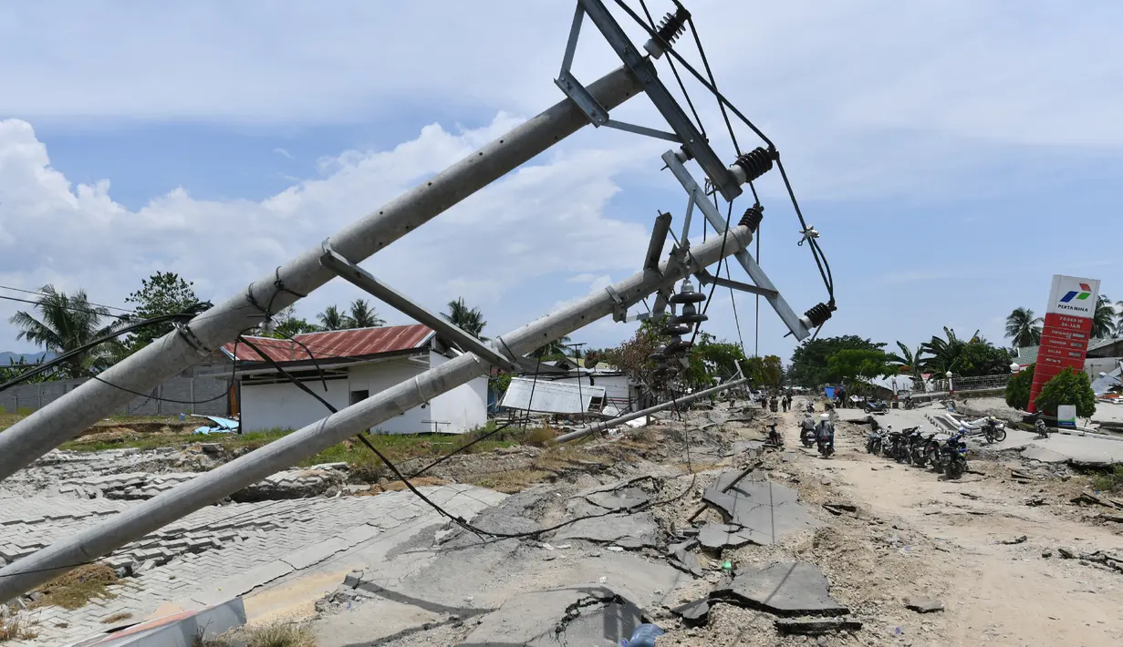 Tiang-tiang listrik roboh usai gempa dan tsunami melanda Kabupaten Sigi, Sulawesi Tengah, Kamis (4/10). Badan Nasional Penanggulangan Bencana (BNPB) mengatakan beberapa lokasi di Sigi terisolir akibat gempa dan tsunami. (ADEK BERRY/AFP)