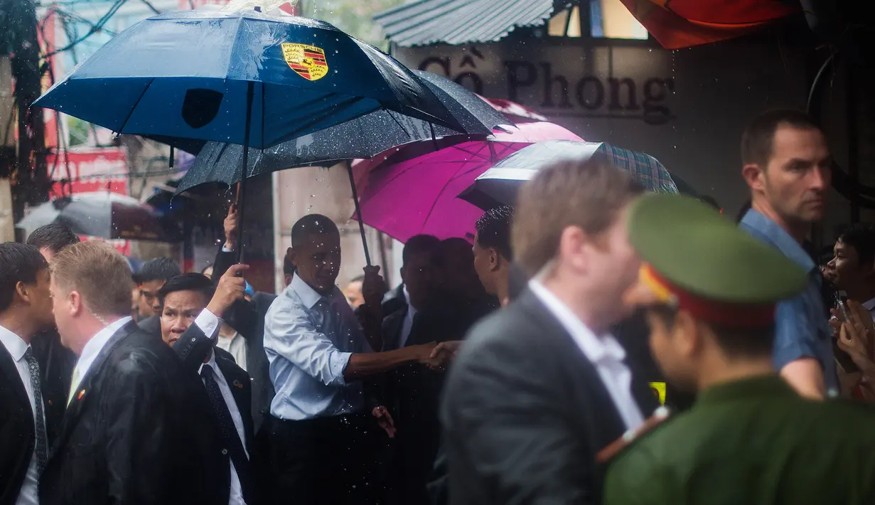 Presiden AS, Barack Obama menyapa warga usai wawancara dengan Anthony Bourdain di area perbelanjaan Hanoi, Vietnam (24/5). Kunjungan Obama ke Vietnam untuk mengakhiri larangan penjualan perlengkapan militer kepada pihak Hanoi. (AFP PHOTO/JIM WATSON)