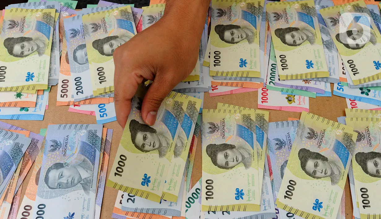 Petugas menata uang rupiah kertas tahun emisi 2022 saat membuka penukaran untuk warga di Hall Basket Gelora Bung Karno (GBK), Jakarta, Minggu (21/8/2022). Masih dalam rangka HUT Kemerdekaan ke-77 Republik Indonesia, Bank Indonesia mengeluarkan uang baru TE 2022 dengan pecahan Rp 100.000, Rp 50.000, Rp 20.000, Rp 10.000, Rp 5.000, Rp 2.000, dan Rp 1.000. (merdeka.com/Arie Basuki)