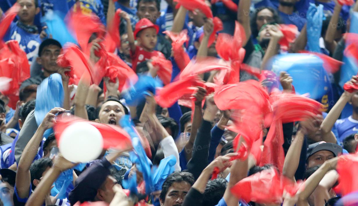 Bobotoh mengibarkan slayer merah, biru, dan putih saat mendukung timnya melawan Persija Jakarta pada Torabika SC 2016 di Stadion Gelora Bandung Lauta Api, Bandung, Sabtu (16/7/2016). (Bola.com/Nicklas Hanoatubun)