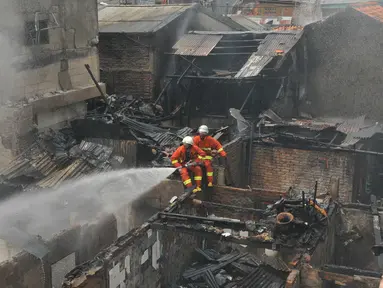Petugas pemadam kebakaran saat mengevakuasi kebakaran yang terjadi di Jalan Kramat Pulo Dalam RT 03 RW 08, Senen, Jakarta, Selasa (3/11/2015). Sekitar 10 rumah hangus akibat kebakaran yang terjadi. (Liputan6.com/Gempur M Surya)