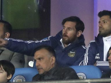 Lionel Messi (tengah) dan Sergio Aguero saat menjadi penonton di tribune pada laga uji coba Argentina melawan Italia di Etihad Stadium, Manchester, Inggris, (23/3/2018). Argentina menang atas Italia 2-0. (Martin Rickett/PA via AP)