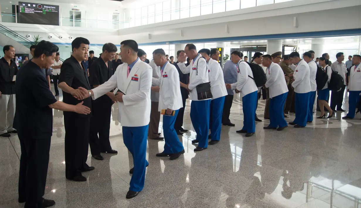 Atlet Korut yang dikepalai Wakil Menteri Olahraga Korea Utara, Won Kil U bersiap meninggalkan bandara internasional Pyongyang, Korut (10/8). Korut akan berpartisipasi dalam Asian Games 2018 di Jakarta dan Palembang, Indonesia. (AFP Photo/Kim Won-Jin)