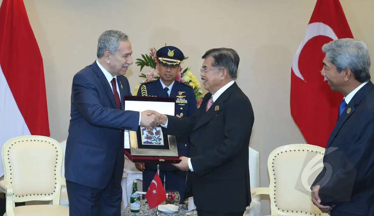 Wapres Jusuf Kalla (kanan) memberikan souvenir kepada Wakil PM Turki, Bulent Arinc (kiri) usai pertemuan bilateral antara Indonesia - Turki dalam Konferensi Asia Afrika 2015 di Jakarta Convention Center, Kamis (23/4/2015). (Liputan6.com/Herman Zakharia)