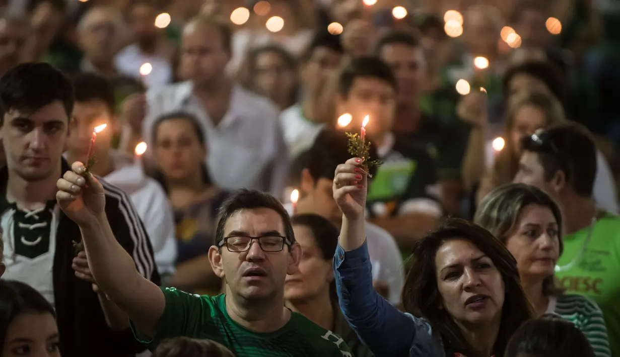 Eskpresi fans Chapecoense yang bernyanyi saat memperingati satu tahun kecelakaan pesawat Lamia 2933 di Arena Conda stadium, Chapeco, Santa Catarina, Brasil, (28/11/2017). Sekitar 19 pemain Chapecoense meninggal. (AFP/Nelson Meida)