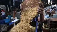 Pekerja tengah mengangkat kacang kedelai untuk dijadikan bahan dasar pembuatan tahu di Jakarta, Rabu (6/1/). Indonesia masih bergantung pada kedelai impor karena minimnya produksi kedelai di dalam negeri. (Liputan6.com/Angga Yuniar)