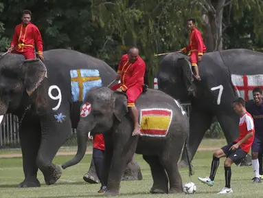 Sejumlah gajah bermain sepak bola dengan badan dilukis bendera peserta Piala Dunia 2018 di Ayutthaya, Selasa (12/6/2018). Kegiatan yang dilakukan Sekolah Ayutthaya Wittayalai ini dilakukan untuk memeriahkan Piala Dunia. (AP/Sakchai Lalit)