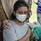 Petugas kesehatan mendampingi seorang anak saat vaksinasi Covid-19 di RPTRA Pulo Besar, Sunter Jaya, Jakarta Utara, Senin (12/7/2021). Saat ini sebanyak 153.000 anak berusia 12-17 tahun telah divaksinasi dari alokasi 20 juta dosis vaksin Covid-19. (merdeka.com/Iqbal S Nugroho)
