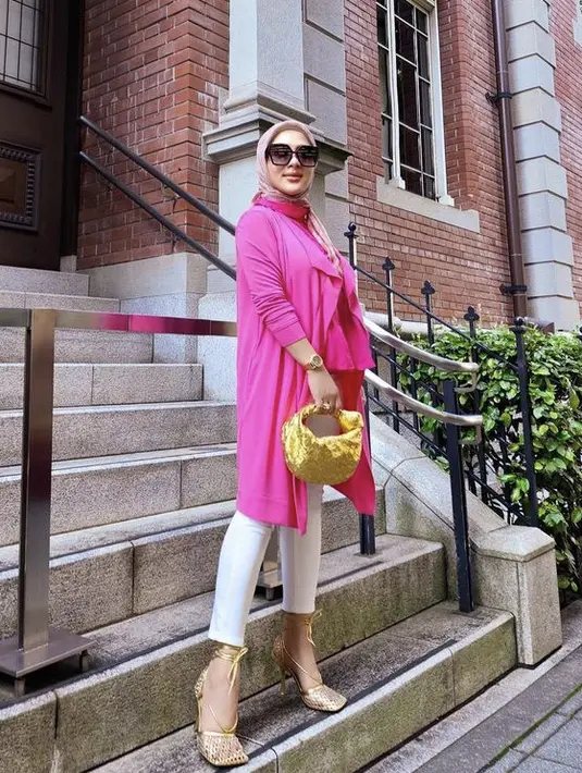 <p>Lalu ia juga tampil bright dengan atasan warna magenta, dipadukan celana panjang putih. Diserasikan denhan heels keemasan dan Bottega Veneta keemasan seharga Rp37 jutaan.&nbsp;@princessyahrini</p>
