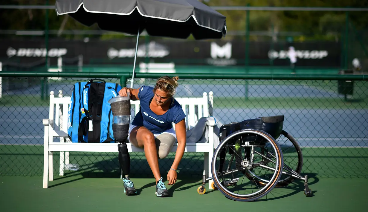 Atlet para tenis Prancis Pauline Deroulede (kiri) menyaksikan sesi latihan turnamen tenis kursi roda French Riviera Open edisi ke-4 di Biot, 28 September 2020. Korban kecelakaan itu kehilangan kaki kirinya pada Oktober 2018. (FRANCK FIFE/AFP)