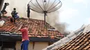 Sejumlah warga memadamkan api membakar pemukiman padat penduduk di kawasan Manggarai, Jakarta, Rabu (10/7/2019). Sebanyak 27 Unit mobil pemadam kebakaran diterjunkan untuk memadamkan api yang melanda pemukiman di dekat Stasiun Manggarai tersebut. (Liputan6.com/Herman Zakharia)