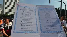 Aktivis yang tergabung dalam Quran Generation membawa Alquran raksasa di Bundaran HI, Jakarta, Minggu (21/12/2014). (Liputan6.com/Herman Zakharia)
