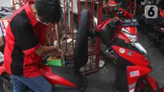 Kurir mengisi baterai sepeda motor listriknya di salah satu gerai ekspedisi jasa di kawasan Jakarta, Senin (5/9/2022). Selain untuk mengikuti anjuran pemerintah, penggunaan motor listrik pada kurir di perusahaan ekspedisi jasa tersebut bertujuan untuk menekan biaya operasional di tengah kenaikan harga bahan bakar minyak (BBM). (Liputan6.com/Herman Zakharia)