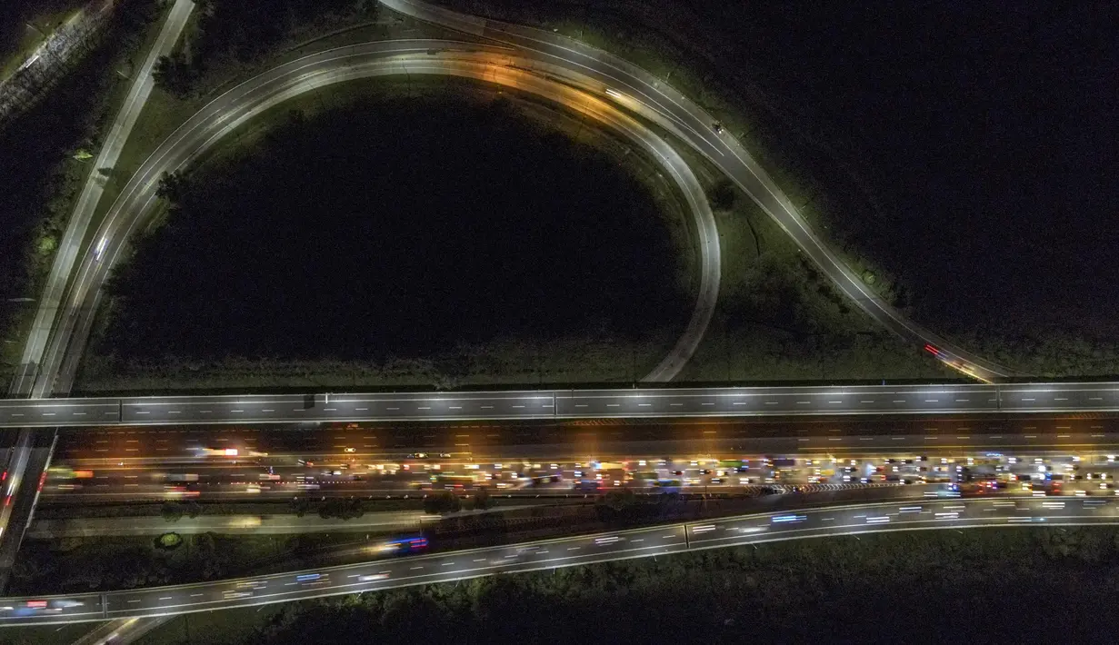<p>Foto udara ini menunjukkan kepadatan kendaraan yang melintas di Jalan Tol Jakarta - Cikampek di Karawang, Jawa Barat pada 28 April 2022. Lalu lintas di Jalan Tol Jakarta-Cikampek mengalami kemacetan panjang memasuki puncak arus mudik Lebaran 2022. (BAY ISMOYO / AFP)</p>
