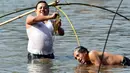Penduduk desa memegang ikan saat mengikuti acara memancing bersama dalam perayaan panen Bhogali Bihu di Danau Goroimari di Panbari, Assam, India, pada 14 Januari 2020. “Bhogali Bihu” menandai berakhirnya musim panen di bagian timur laut negara bagian Assam. (Xinhua/Str)