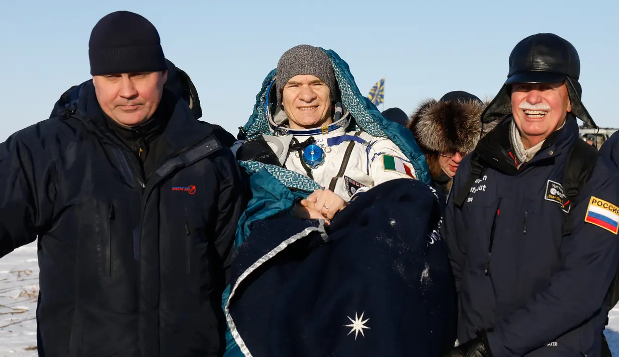 Tim penyelamat antariksa Rusia membantu kosmonot Rusia Sergey Ryazanskiy usai berhasil melakukan pendaratan di Kazakhstan (14/12). Tiga astronot ini terdiri dari tiga negara yaitu AS, Rusia dan Italia. (AP/ Dmitri Lovetsky/Pool)