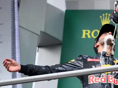 Pembalap Red Bull Daniel Ricciardo meminum sampanye dengan menggunakan sepatu saat merayakan keberhasilannya naik podium pada Grand Prix Formula 1 Jerman, Minggu (31/7). Pembalap asal Australia itu finis sebagai runner-up. (Patrik STOLLARZ / AFP)