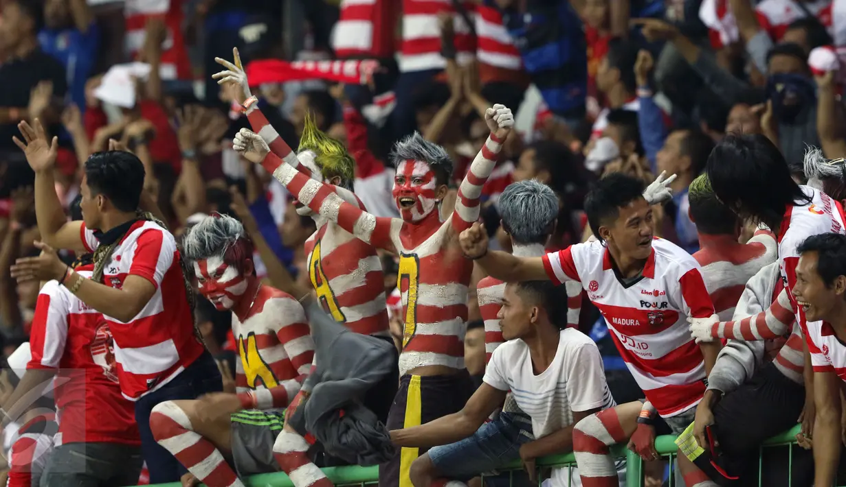 Suporter Madura United bersorak saat menyaksikan timnya unggul atas Persija pada lanjutan Liga 1 di Stadion Patriot Candrabhaga, Bekasi, Kamis (4/5). Madura United FC unggul 1-0. (Liputan6.com/Helmi Fithriansyah)