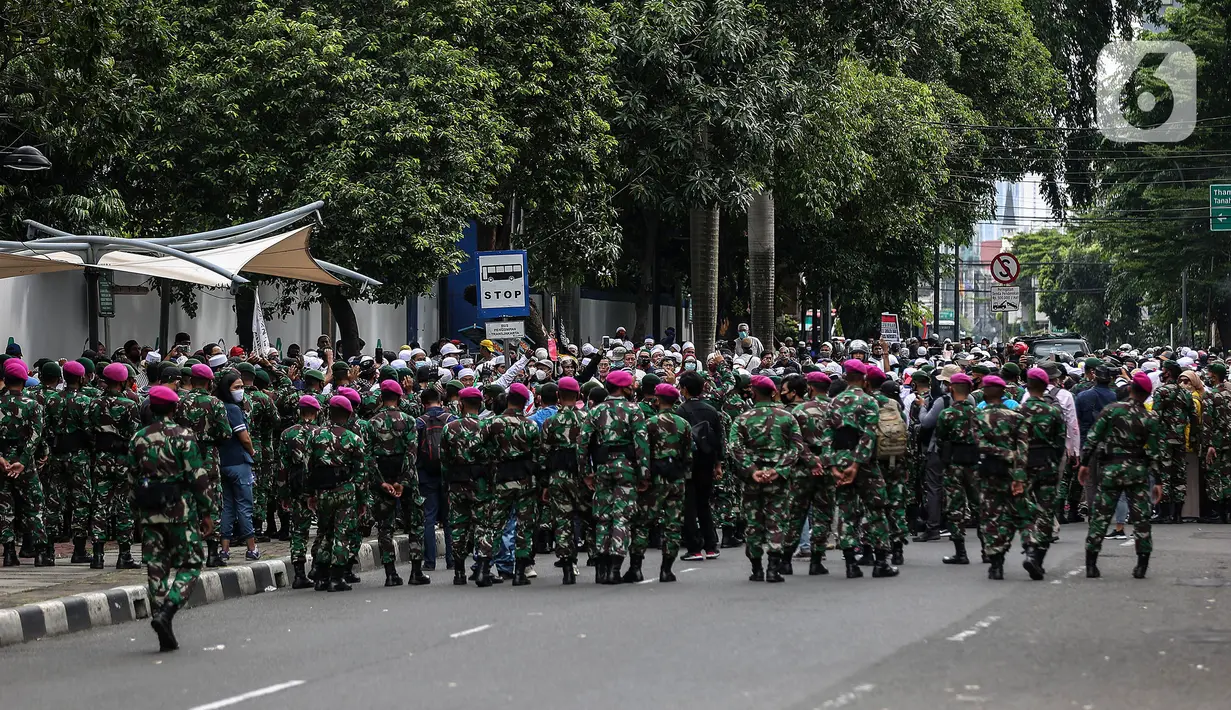 Prajurit TNI menghalau massa yang hendak menggelar demonstrasi 1812 di sekitar Istana Negara, Jakarta, Jumat (18/12/2020). Massa Aksi 1812 dihimbau oleh aparat yang bertugas agar membubarkan diri dan tidak berkerumun demi menghindari penyebaran COVID-19. (Liputan6.com/Johan Tallo)