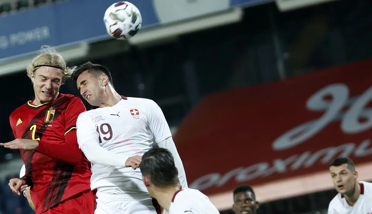 Penyerang Belgia, Sebastiaan Bornauw bersaing dengan bek Swiss,  Haris Seferovic dalam pertandingan persahabatan di King Power Stadion At Den Dreef, Kamis (12/11/2020) dini hari WIB. Timnas Belgia Belgia mengalahkan Swiss dengan skor 2-1. (AP Photo/Francisco Seco)