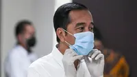Presiden Joko Widodo merapihkan masker yang digunakannya saat meninjau Rumah Sakit Darurat Penanganan COVID-19 Wisma Atlet Kemayoran, Jakarta, Senin (23/3/2020). Dalam kunjungannya Jokowi memastikan Rumah Sakit Darurat siap digunakan untuk menangani 3.000 pasien. (ANTARA FOTO/Hafidz Mubarak A/Pool)