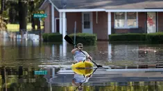 Parker Uzzell mendayung kano untuk aktivitas di tengah banjir yang melanda wilayah Lumberton di Carolina Utara, Amerika Serikat, 12 Oktober 2016. Banjir akibat badai Matthew tersebut merendam kota berpenduduk 21.000 orang itu. (REUTERS/Randall Hill)