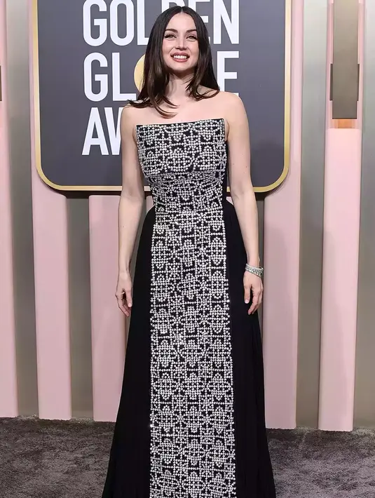 <p>Ana de Armas memilih gaun Louis Vuitton untuk menghadiri Golden Globes 2023. Gaun beludru hitam bersulam putih ini tentu menarik perhatian, dengan aksesori yang juga berasal dari Louis Vuitton High Jewelry Collection. Foto: People.</p>