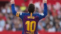 Penyerang Barcelona Lionel Messi menunjuk langit usai mencetak gol ke gawang Sevilla pada laga La Liga di Stadion Ramon Sanchez Pizjuan, Sevilla, Sabtu (23/2). Messi mencetak hattrick. (JORGE GUERRERO/AFP)
